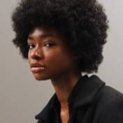 A portrait of a black woman in a black shirt